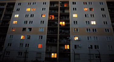 Photo d'un immeuble dans la nuit avec des fenêtres éclairées