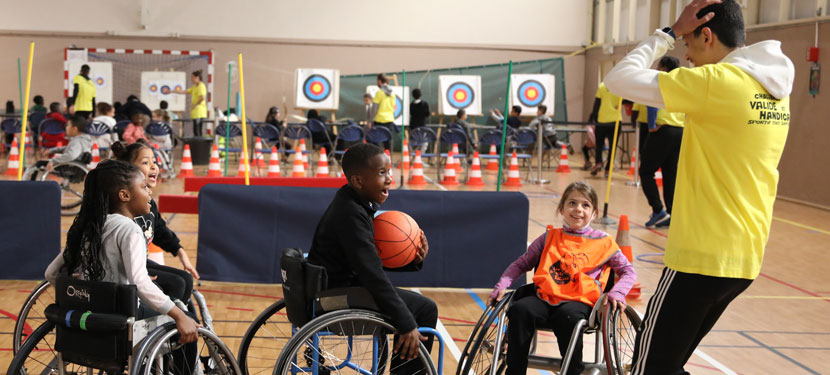De jeunes enfants en fauteuil roulant en train de jouer au basket