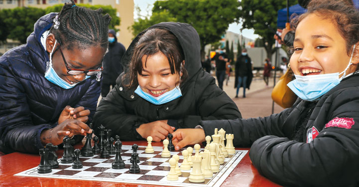 Trois jeunes filles jouent aux échecs