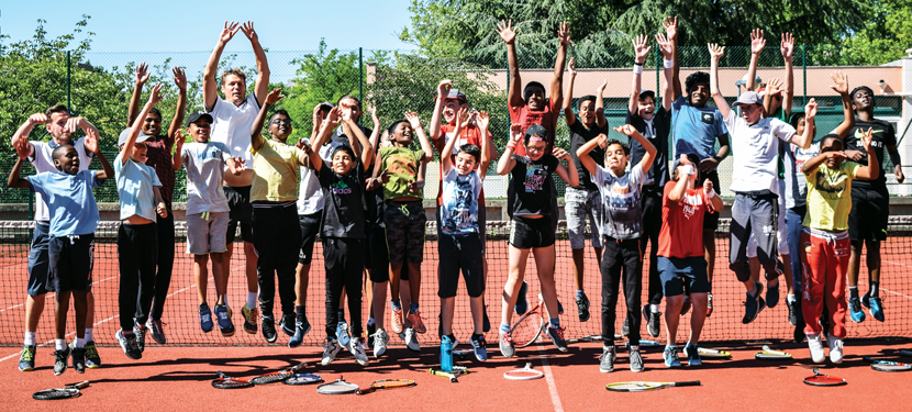 Photo d'enfants et animateurs en train de sauter sur le cour de tennis