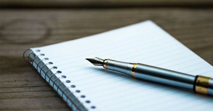 Photo d'un stylo posé sur un cahier